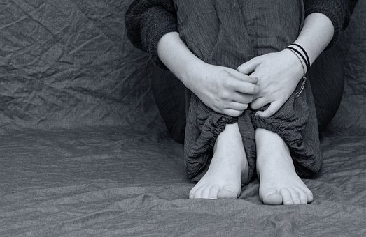 person sitting at a textile grayscale photo